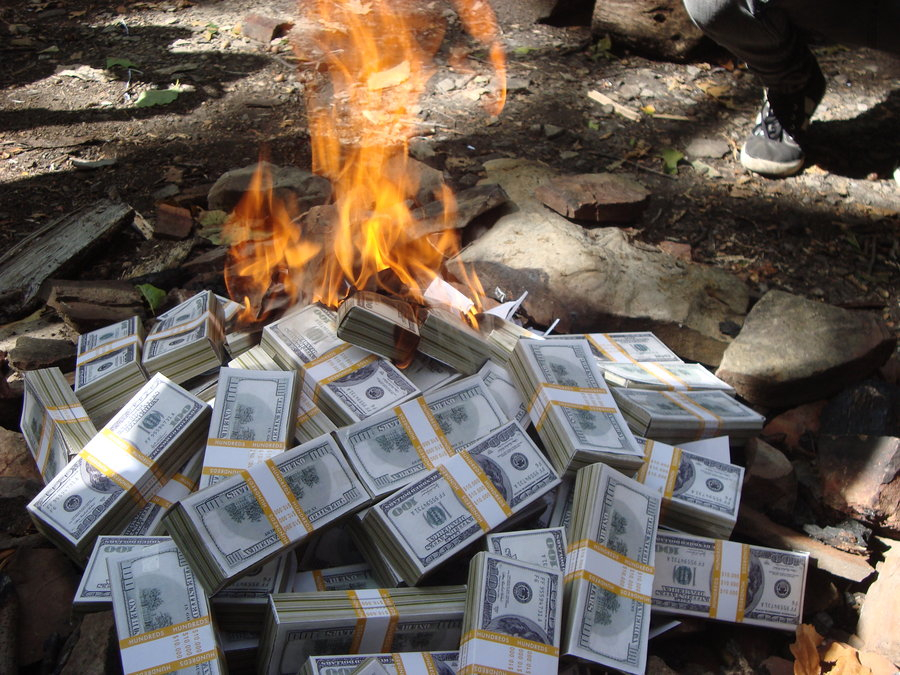 Сжигание денег. Сжигает деньги. Костер из долларов. Деньги горят. Сожжение денег.
